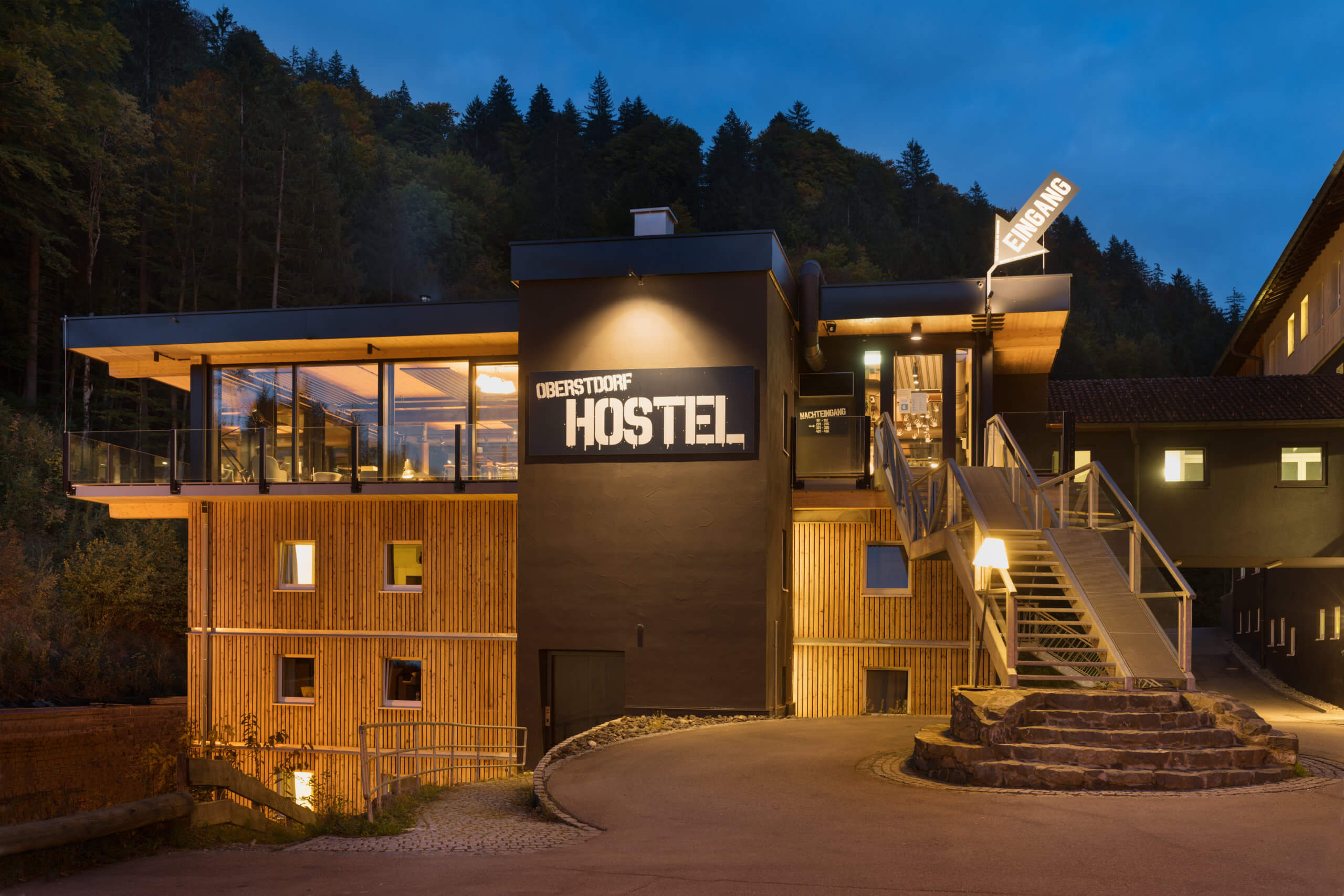 Das Bild zeigt eine Aussenansicht des Oberstdorf Hostel bei Nacht.