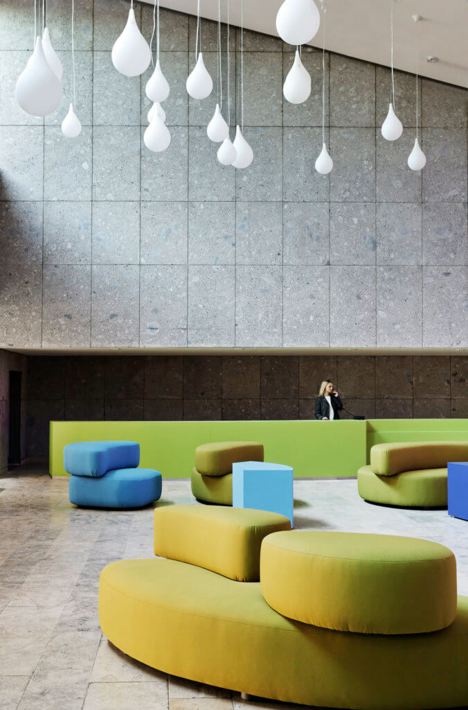 Loungebreich mit farbigen Sitzmöbeln, Wände aus Beton im Kurhaus Oberstdorf.