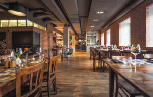 Das Bild zeigt den Gastraum der Martha Pizzarei Fürstenfeldbruck mit vielen Holztischen.