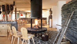 Das Foto zeigt den Restaurantbereich des Hotel Oberstdorf mit Sitzplatz am Kamin.