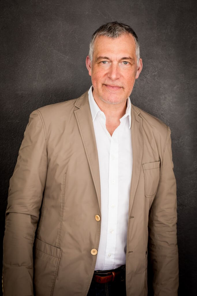 Die Portraitfotgrafie zeigt camp Geschäftsführer Peter Trunzer. Er trägt ein beiges Sakko über einem weißen Hemd.